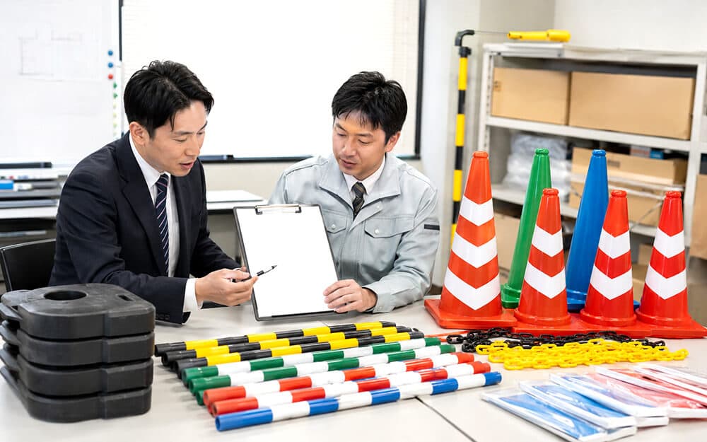 カラーコーンや安全用品の導入チェックリストを確認する購買担当者