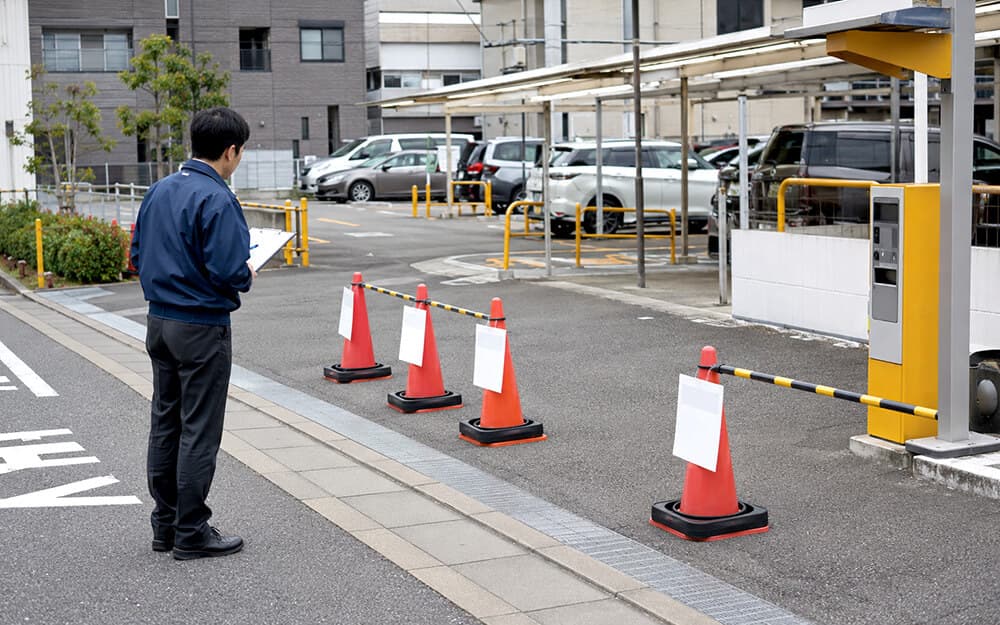 駐車場でカラーコーンと表示カバーを使って区画整理する様子